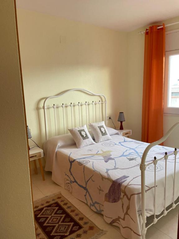 a bedroom with a white bed with pillows on it at Apartamento tranquilo en Roses centro cerca de la playa Costa brava in Roses