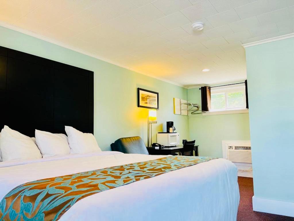 um quarto de hotel com uma cama grande e uma secretária em Wells Moody Motel em Wells