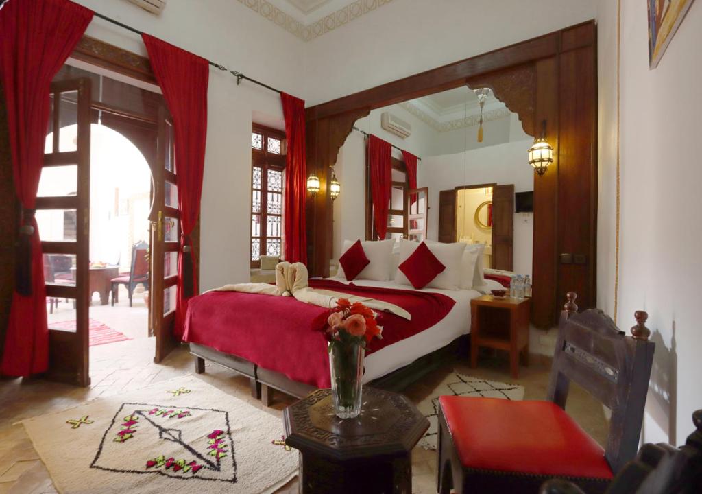 a bedroom with a large bed with a red blanket at Riad Morocco Sky in Marrakesh