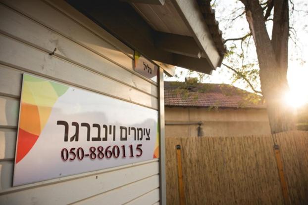 una señal en el lateral de un edificio en Weinberger Zimmers, en She'ar Yashuv