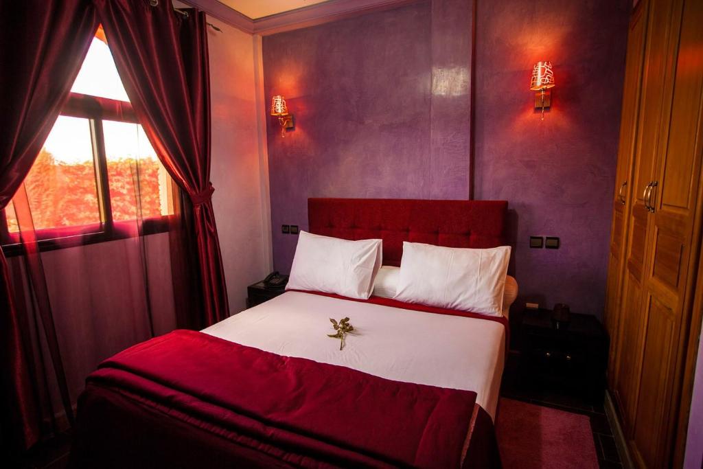 Un dormitorio con una cama roja y blanca y una ventana en Toubkal appart hotel, en Tahannout