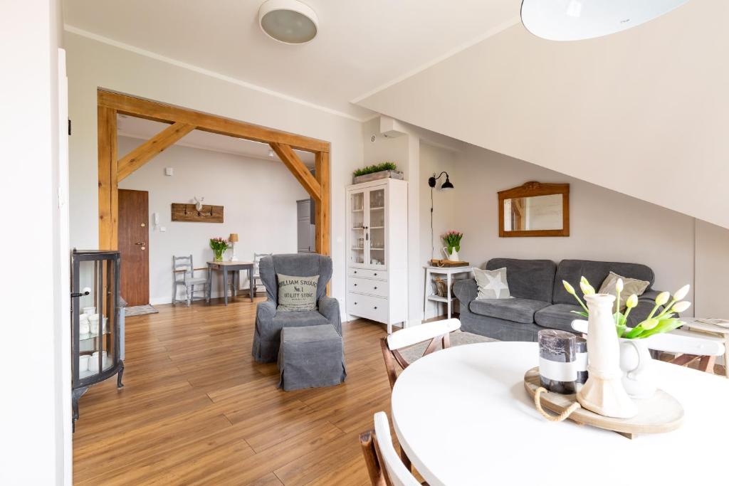 ein Wohnzimmer mit einem Sofa und Stühlen in der Unterkunft Apartament Wigilijna Premium Starówka in Elblag