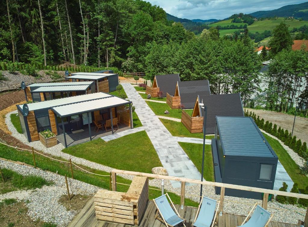 Natura Fina Resort في Ravne na Koroškem: اطلالة جوية على منتجع فيه كراسي ومنزل