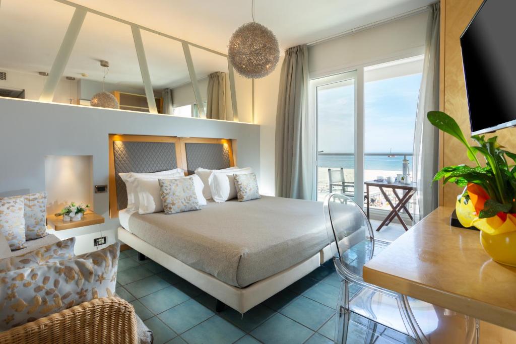 a bedroom with a bed with a view of the ocean at Club House Hotel in Rimini