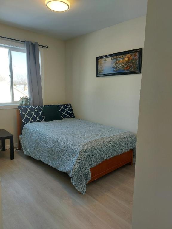 a small bedroom with a bed and a window at Harbison in Winnipeg