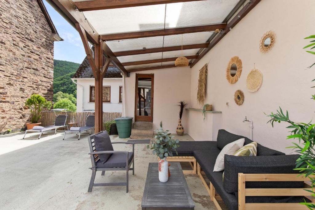 eine Terrasse mit einem Sofa und einem Tisch in der Unterkunft Haus Blaue Traube mit moselblick in Ediger-Eller