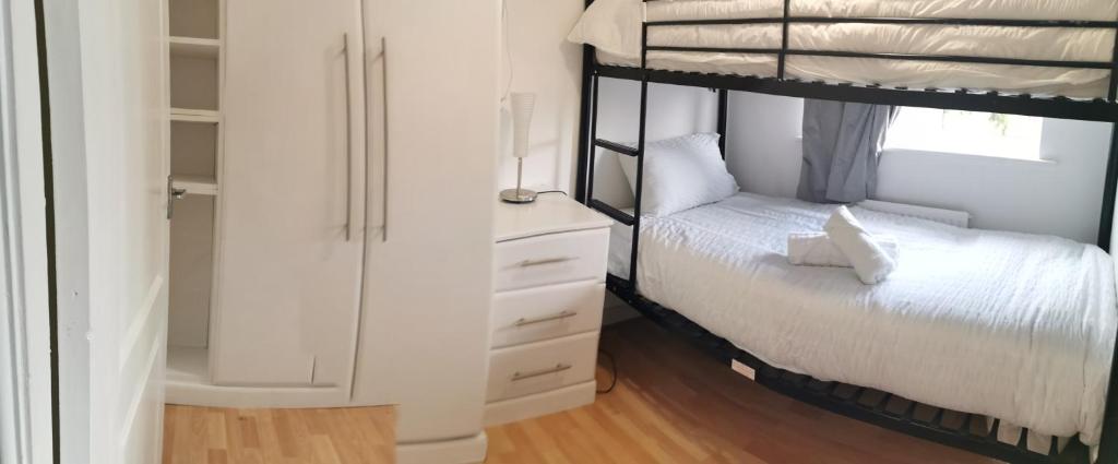 ein Schlafzimmer mit einem Etagenbett und einer Kommode in der Unterkunft Hinchley House - Your Manchester Haven in Manchester