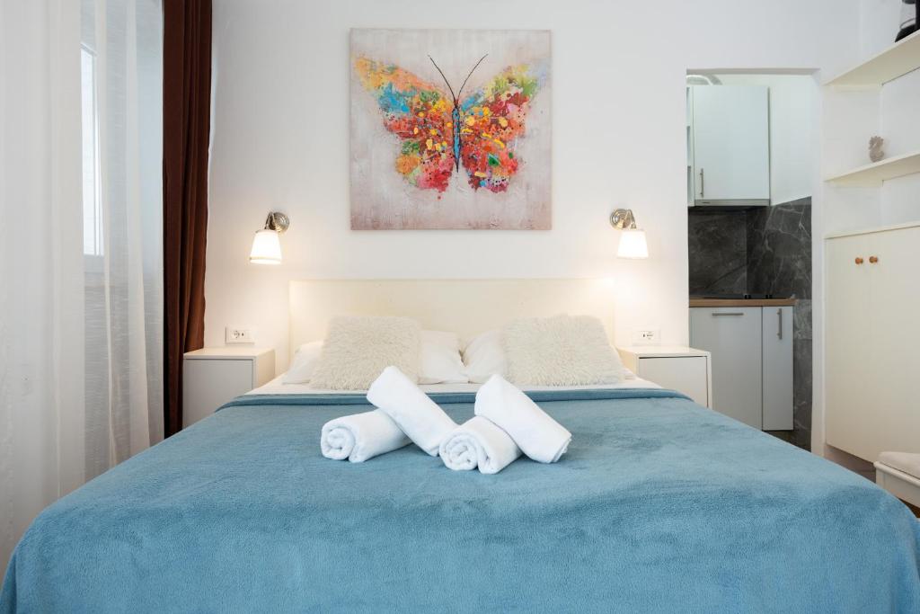 a bedroom with a blue bed with two towels at Cosmai Residence in Dubrovnik
