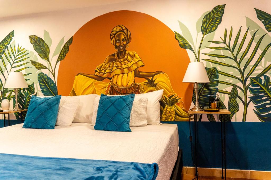 Schlafzimmer mit einem Kingsize-Bett und einem Gemälde an der Wand in der Unterkunft Candilejo Hotel Boutique in Cartagena de Indias