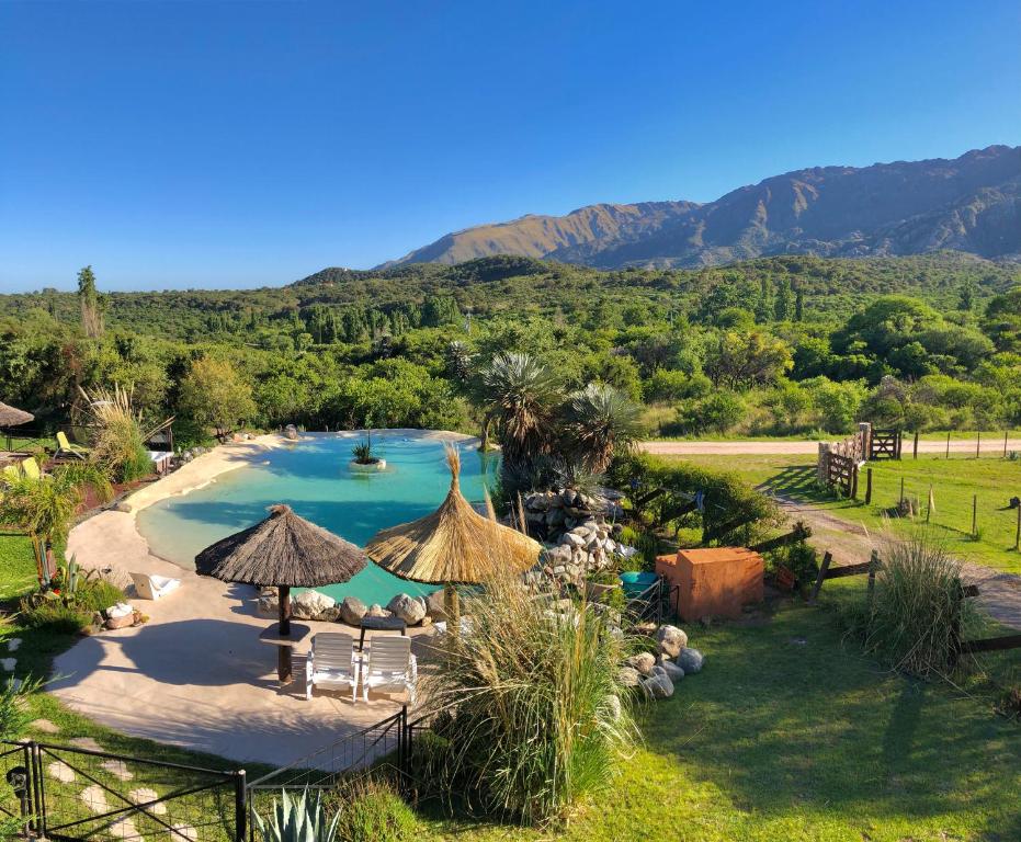 a pool with chairs and umbrellas in a resort at Fragancias Serranas in Cortaderas