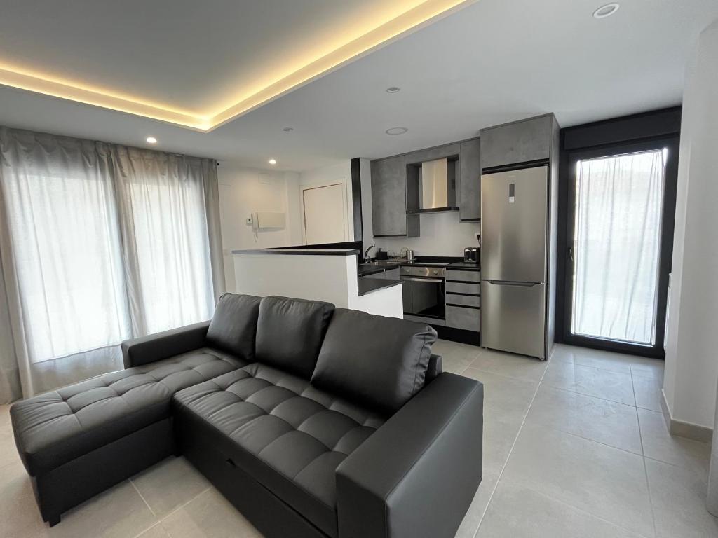 uma sala de estar com um sofá e uma cozinha em Apartamentos Cella em Cella