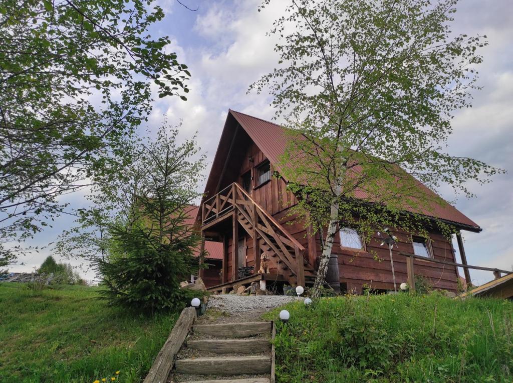 una casa de madera con escaleras que conducen a ella en Zakątek Włóczykija en Cisna