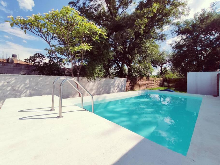 uma piscina num quintal com um jardim de jardim com uma decoração robiótica em Casa Mango amplia con alberca y cerca de la Media Luna !!! em Río Verde