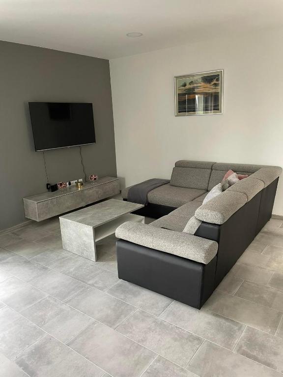 a living room with two couches and a flat screen tv at Apartman Ivanica in Lukoran