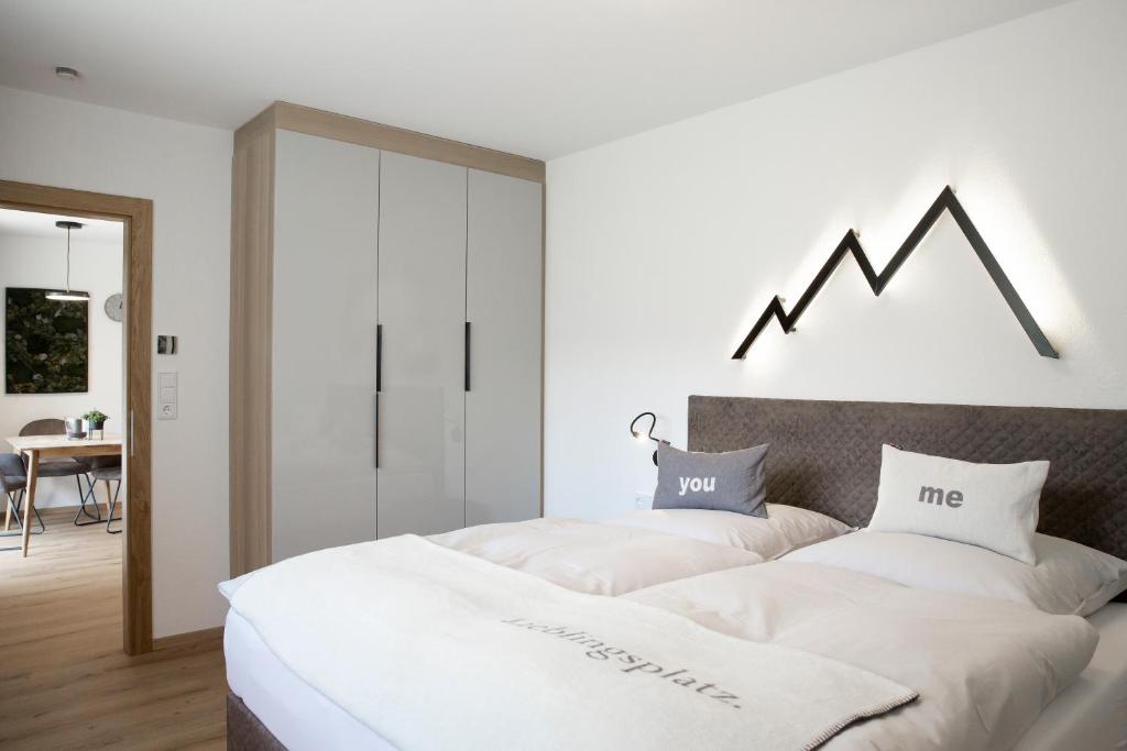 1 dormitorio con 1 cama grande con sábanas blancas en Starla 4, en Sankt Anton am Arlberg