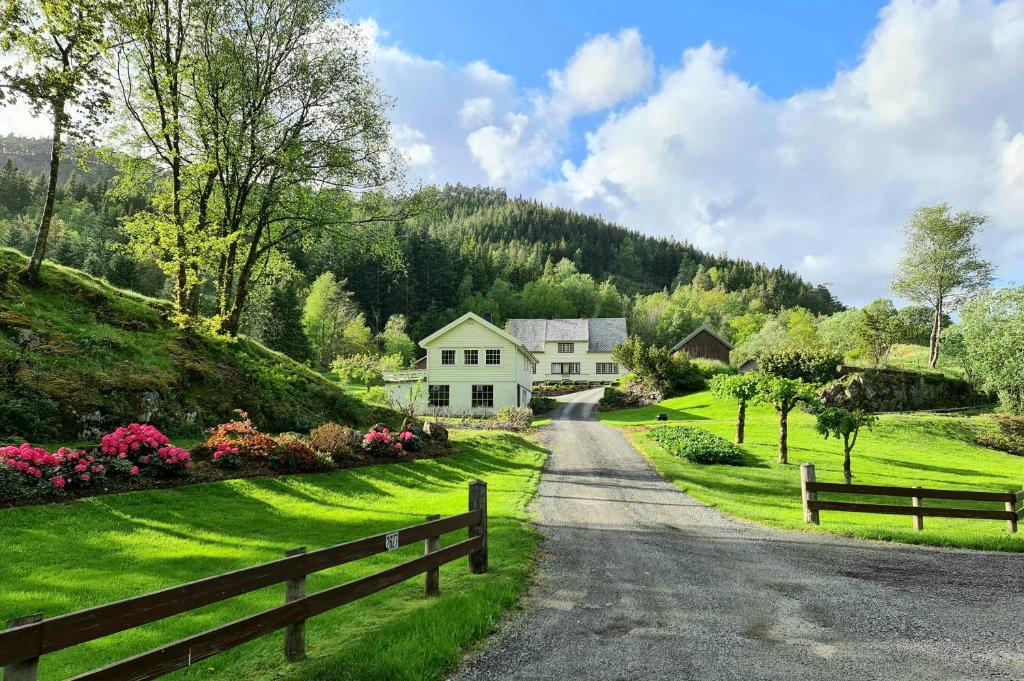 un camino que conduce a una casa blanca con una valla en Ropeid Fjordferie, en Ropeid