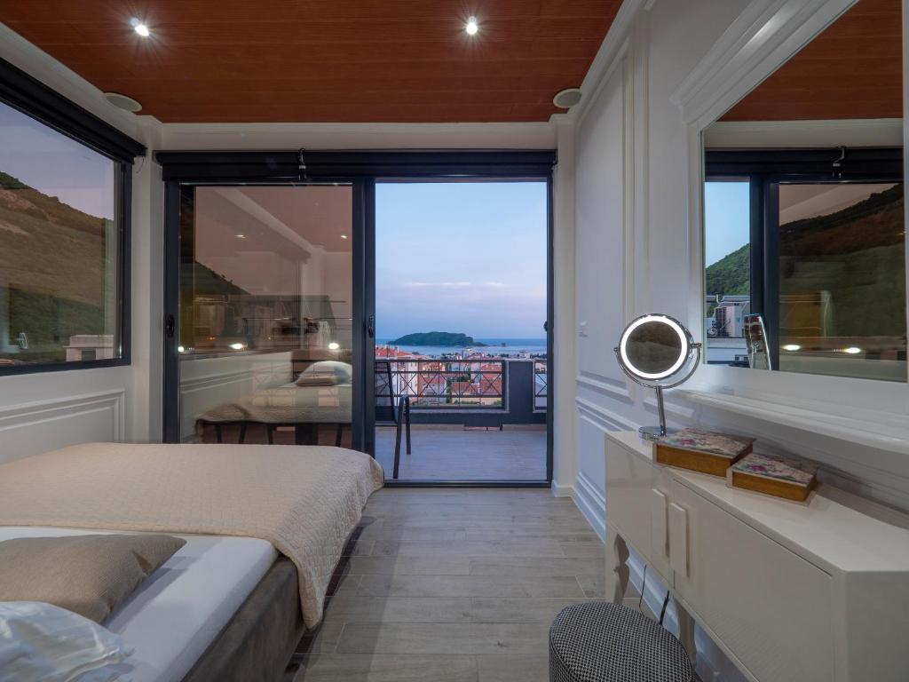 um quarto com uma cama e vista para o oceano em Misisuone Apartments Budva em Budva