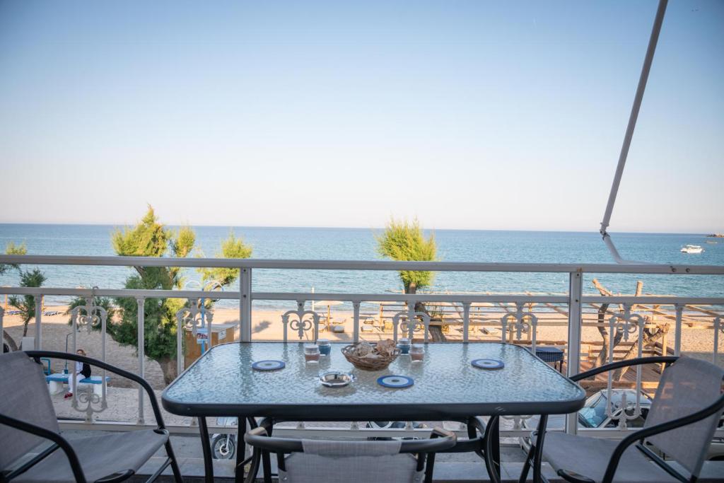 a table on a balcony with a view of the beach at Daisy's room in Archangelos
