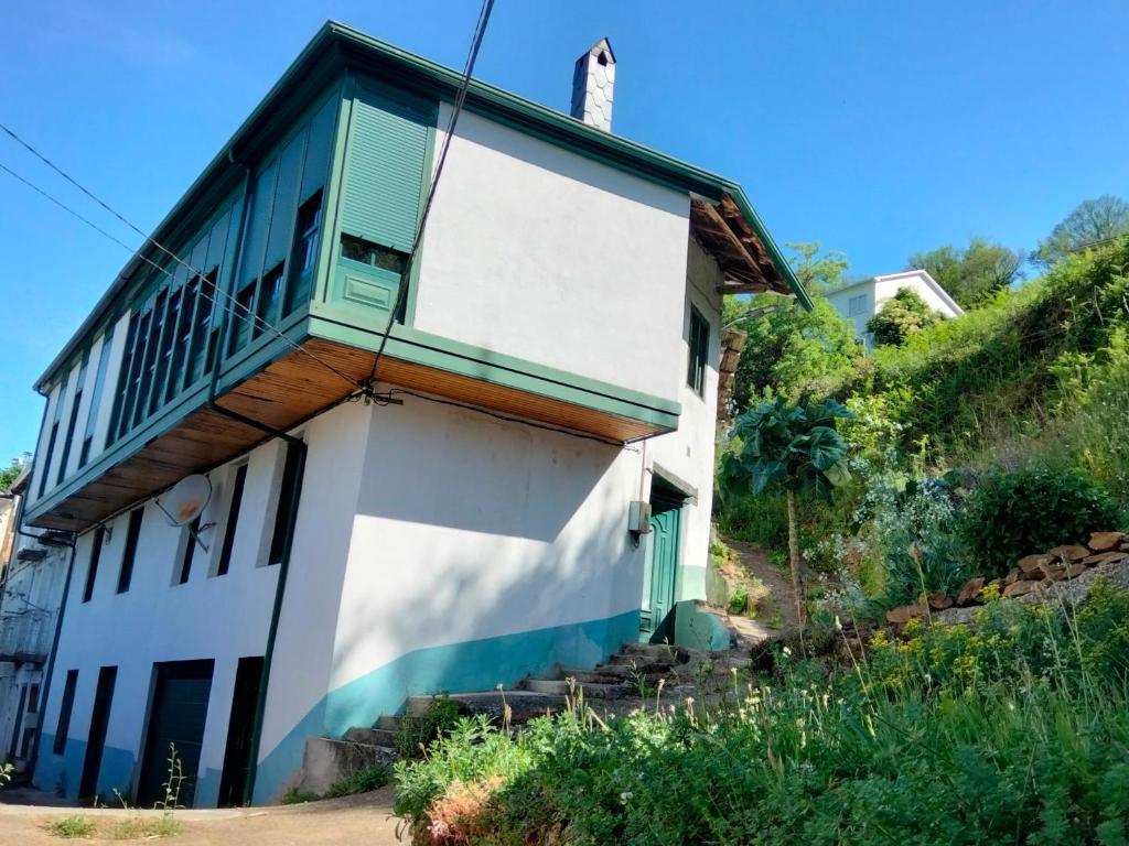 a house with a balcony on the side of it at Casa Fidel. in Seoane