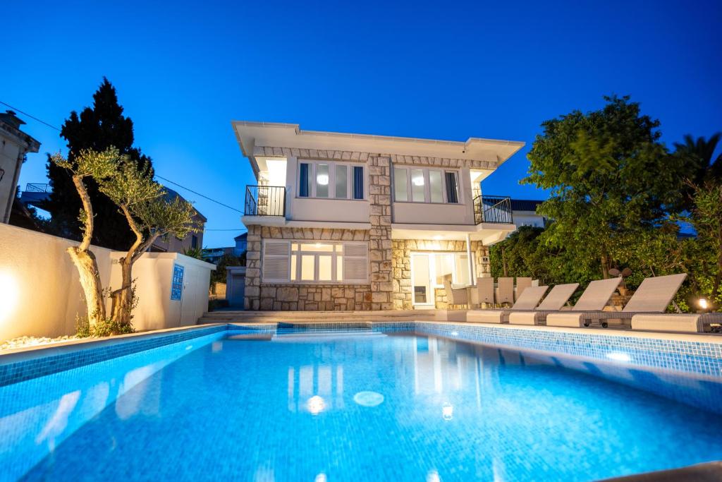 uma grande piscina em frente a uma casa em Villa Lucini Dvori em Novalja