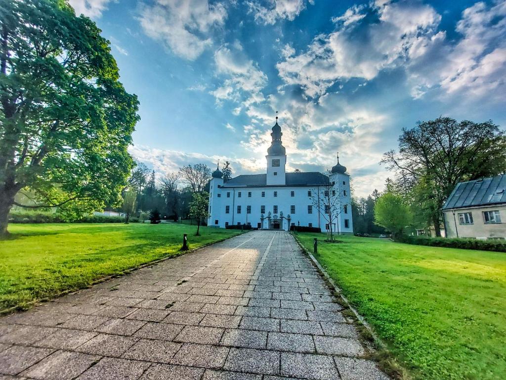 ein großes weißes Gebäude mit einem Uhrturm oben in der Unterkunft Zámek Třešť in Třešť