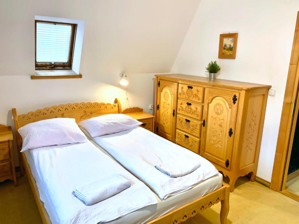 um quarto com uma cama e uma cómoda em madeira em Domek Maria Mąka em Zakopane