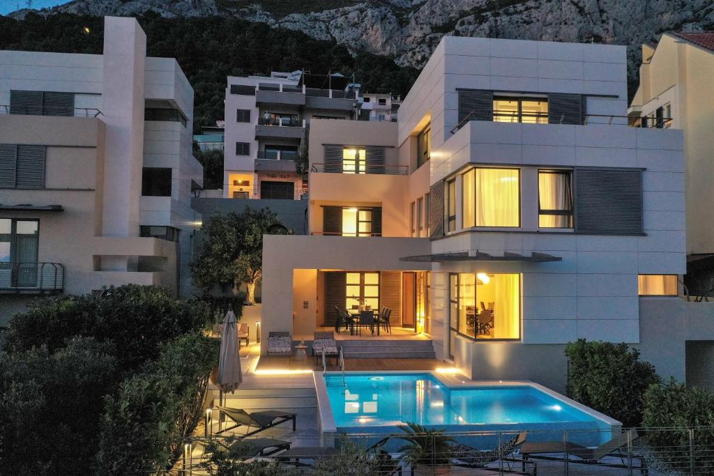 uma casa com uma piscina em frente em Villa Specia em Makarska