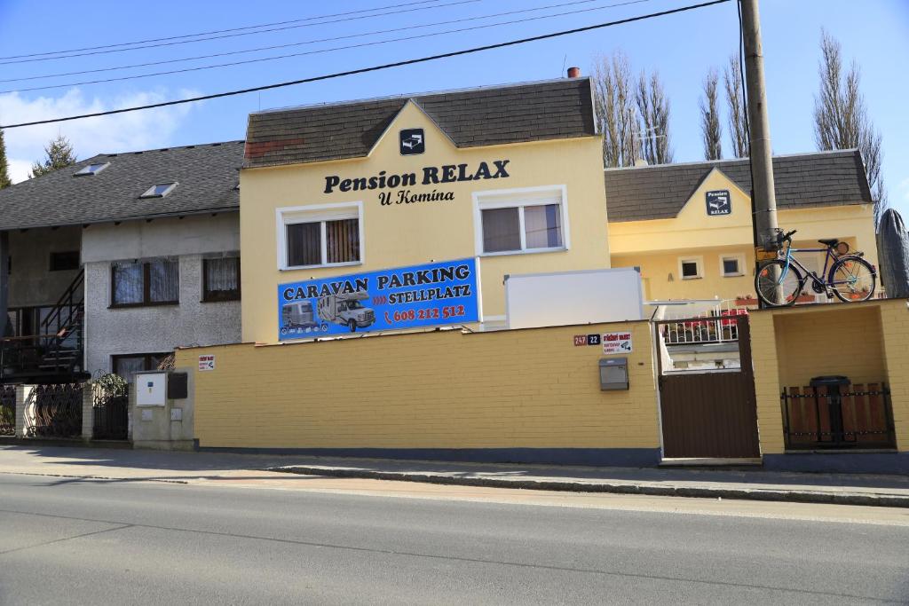 een geel gebouw met een bord aan de zijkant bij Pension RELAX U Komína in Františkovy Lázně