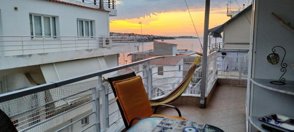 a balcony with a table and chairs on a building at Διαμέρισμα για 4 με θέα θάλασσα σε ήσυχη γειτονιά in Chalkida