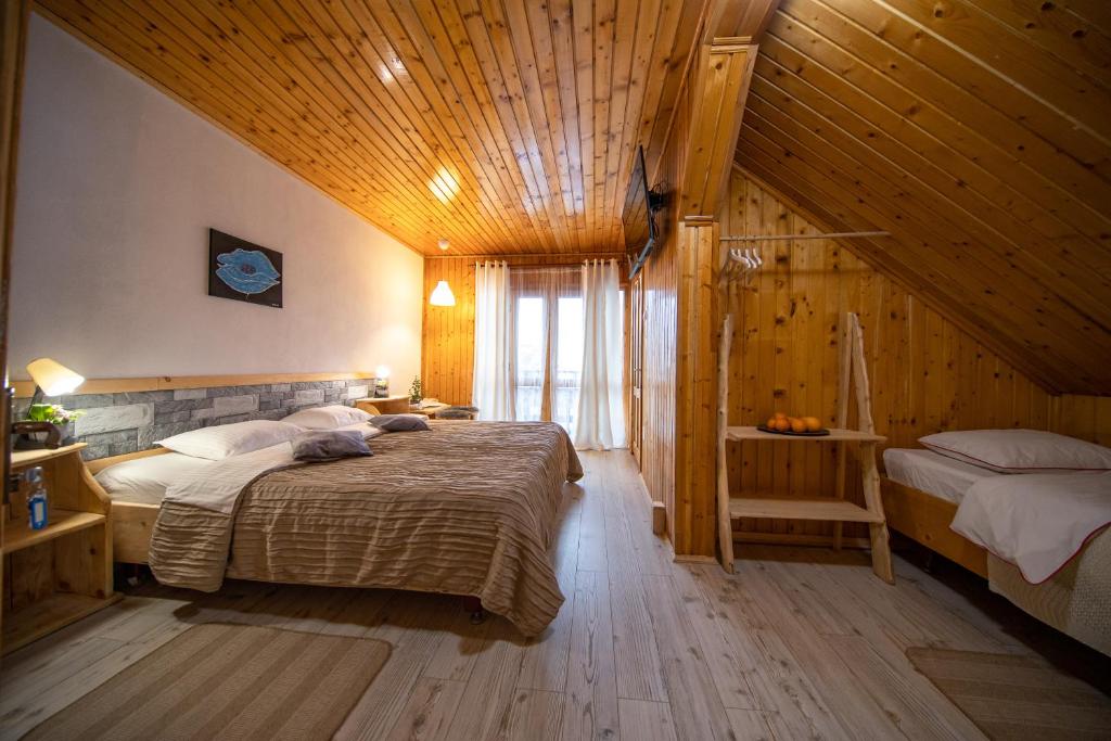 1 Schlafzimmer mit 2 Betten und Holzdecke in der Unterkunft Poiana Cristian in Poiana Brașov