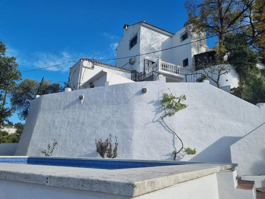 - un bâtiment blanc avec un escalier devant dans l'établissement Casa Loko, à Coín