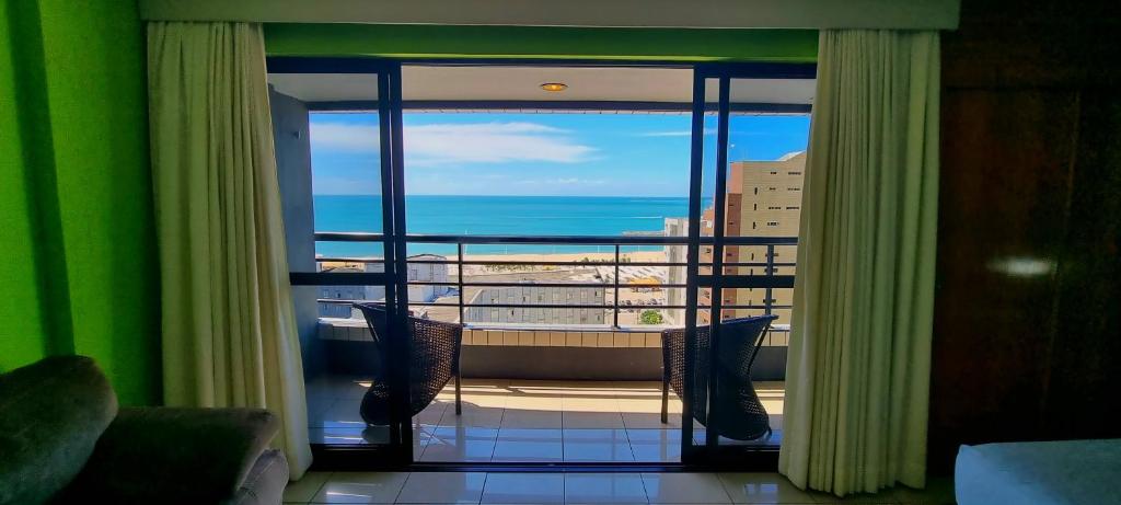 Habitación con vistas al océano desde una ventana en Praia Mansa Flat, en Fortaleza