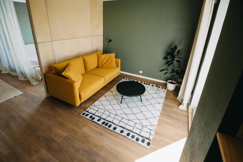 ein Wohnzimmer mit einem gelben Sofa und einem Teppich in der Unterkunft Hubane korter Viljandi vanalinnas in Viljandi