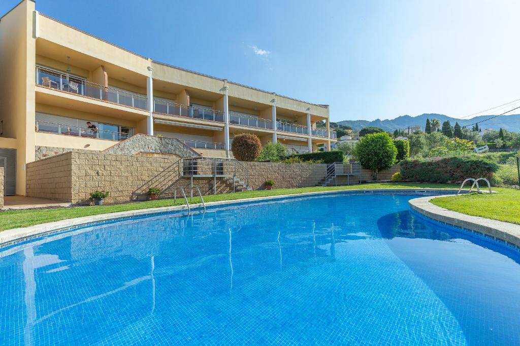 a large swimming pool in front of a building at V016 - SUN VILLAGE in Palau-Saverdera