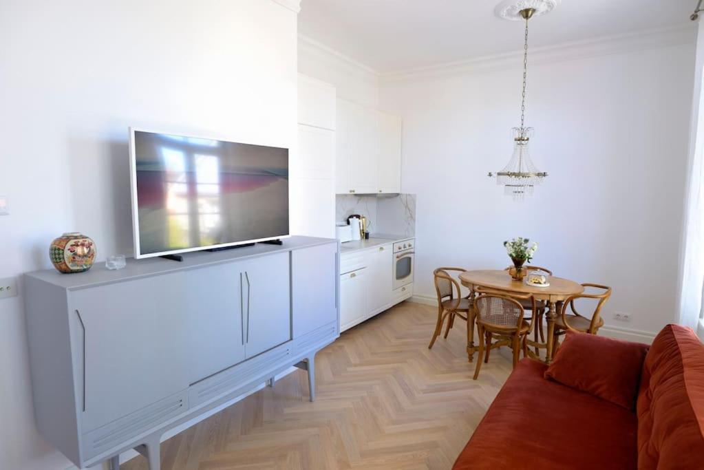 uma sala de estar com um sofá e uma televisão num armário em Lovely 2-bedroom apartment with free parking em Haapsalu