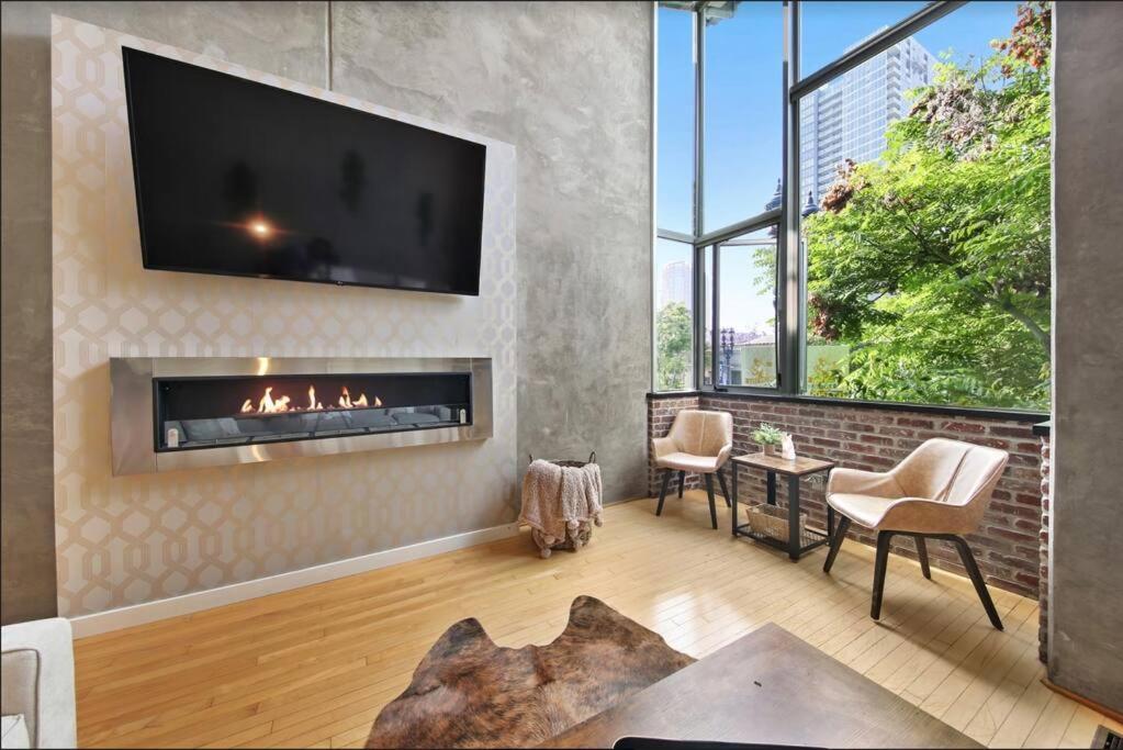 sala de estar con chimenea y TV en New York Style Penthouse in the heart of the city, en San Diego