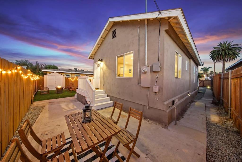 un patio trasero con una mesa de madera y sillas y una casa en Trendy San Diego Home with Outdoor Space, en San Diego