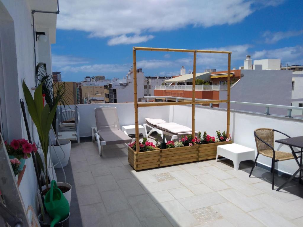 einen Balkon mit einem Tisch und Stühlen auf dem Dach in der Unterkunft Edificio Triana St 47 in Las Palmas de Gran Canaria