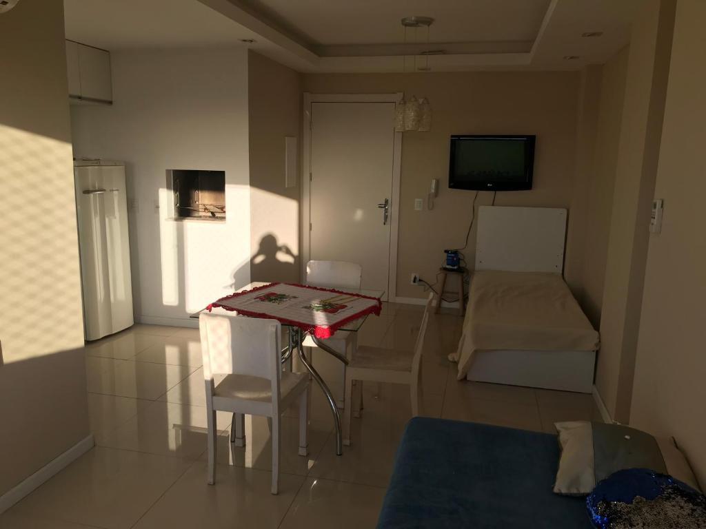 uma pequena sala de estar com uma mesa e um sofá em Apartamento p/ 8 com garagem churasqueira e piscina em Porto Alegre