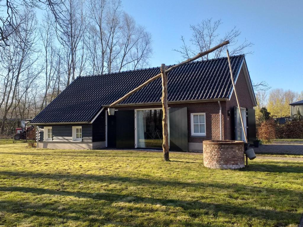 una casa con un tetto di metallo su un cortile di De Donksehoeve a Liempde