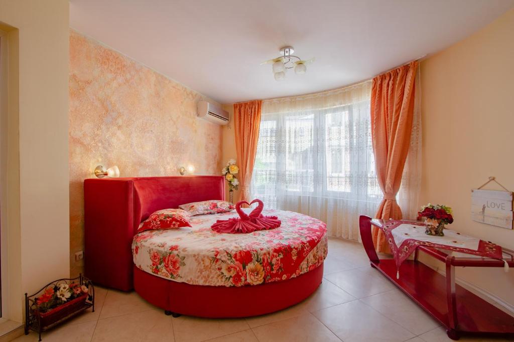 a bedroom with a red bed and a window at Boutique Guest House 'Sofia' in Nesebar