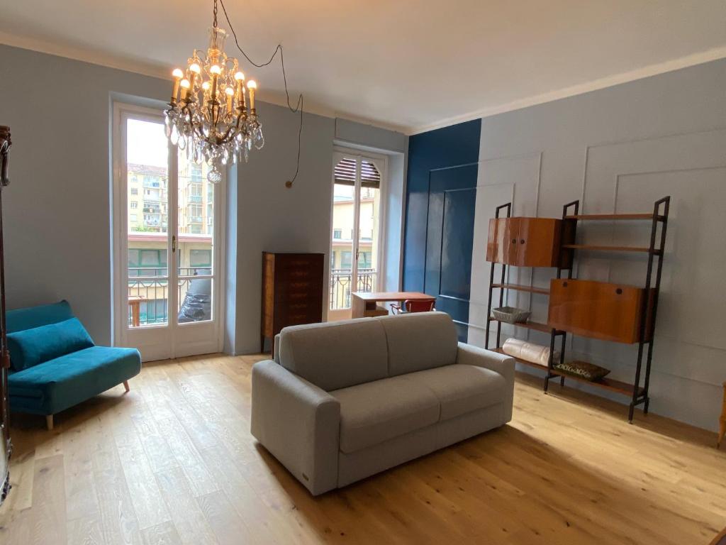 ein Wohnzimmer mit einem Sofa und einem Stuhl in der Unterkunft casa liberty Di&Pi in Turin