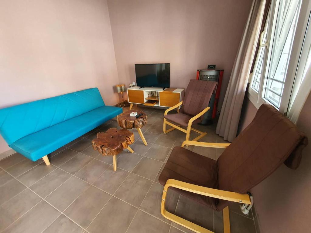 a living room with a blue couch and chairs at Lotaki the friendly house in Limenaria
