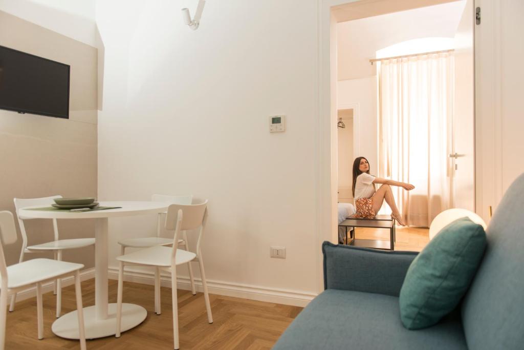 a woman sitting in a chair in a living room at Le Dimore di Puglia - Palazzo Ladogana in Monopoli