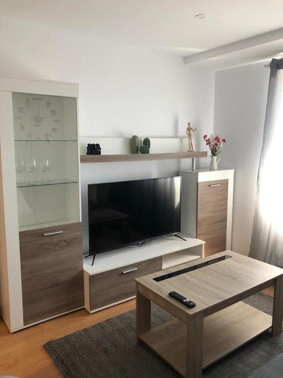 a living room with a large television and a coffee table at BRiSaS DeL NoRTe in Gijón