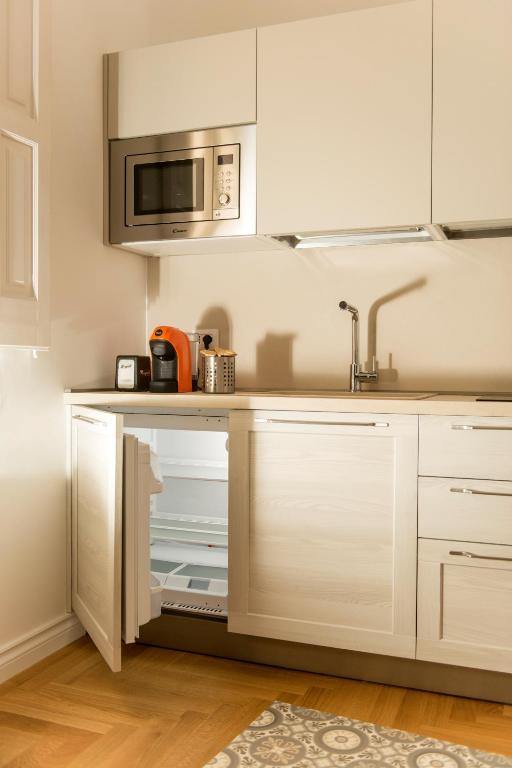 a kitchen with white cabinets and a microwave at Le Dimore di Puglia - Palazzo Ladogana in Monopoli