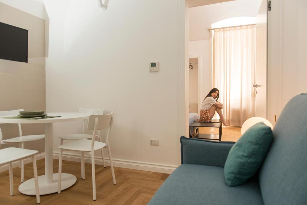 a woman sitting in a chair in a living room at Le Dimore di Puglia - Palazzo Ladogana in Monopoli