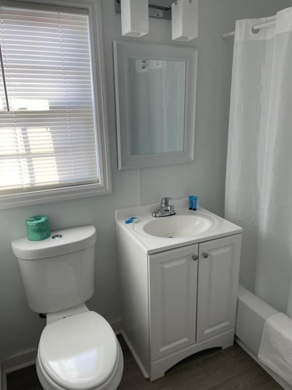 a white bathroom with a toilet and a sink at Sunburst Hotel in Myrtle Beach