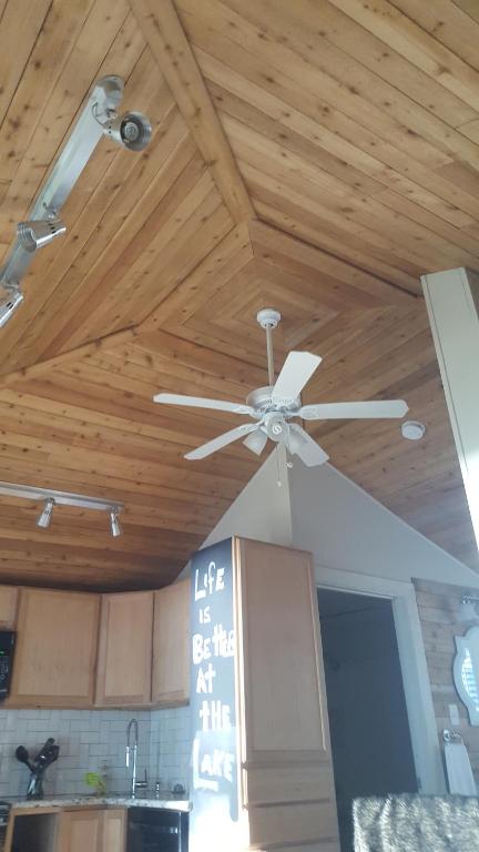 a ceiling fan in a kitchen with wooden ceilings at Lake Front cottage in Little Elm