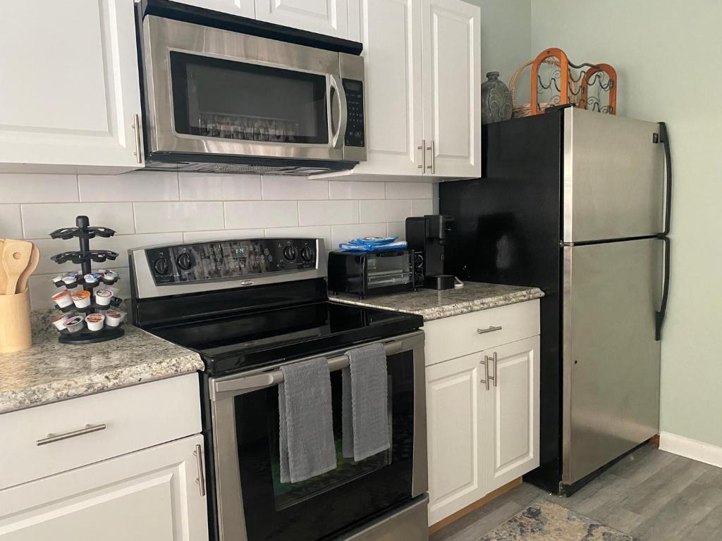 a kitchen with a microwave and a refrigerator at 5 min to Beaches! Biz Ready Large Living Room Fenced Backyard Patio Grill Firepit Driveway Parking in Lake Worth